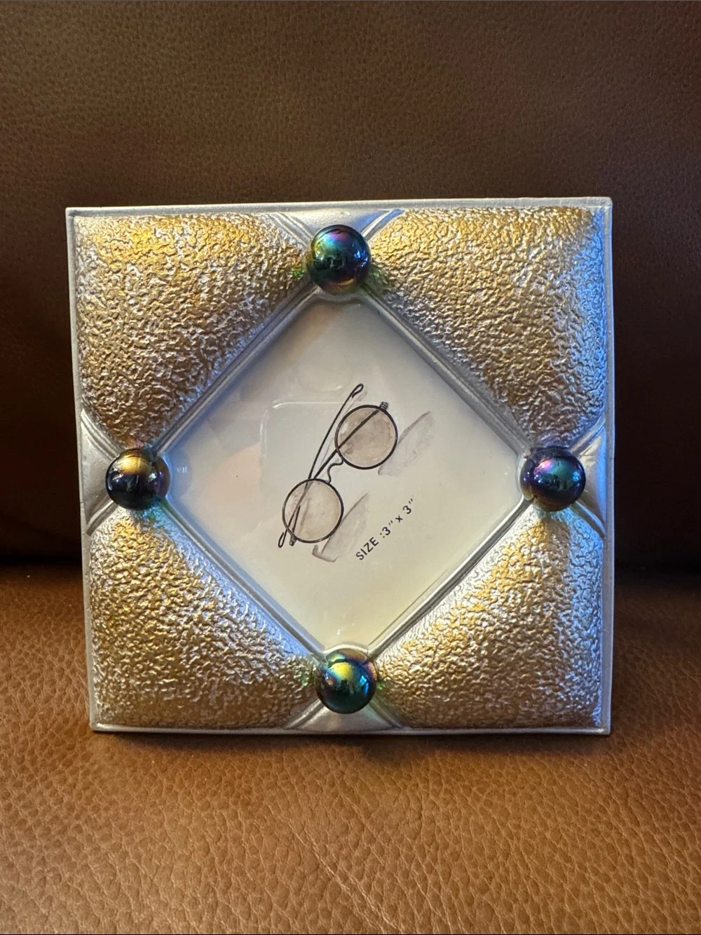 Gold and gray textured picture frame with purple iridescent marbles